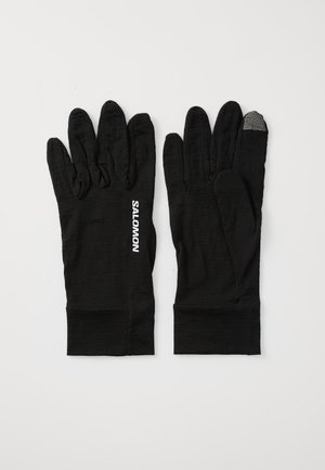 Black gloves made from a textured fabric, featuring finger segmentation and a touch-sensitive fingertip. "SALOMON" logo in white on the side.
