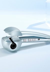 Automatische haarkruller met een slank zilver ontwerp, ronde vorm, gebogen bovenkant en knoppen op de handgreep voor verschillende instellingen.