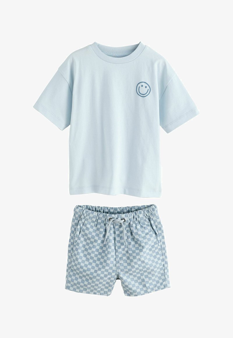 T-shirt bleu clair à manches courtes avec un petit visage souriant sur la poitrine, associé à un short à carreaux bleu clair et blanc avec une taille à cordon de serrage.