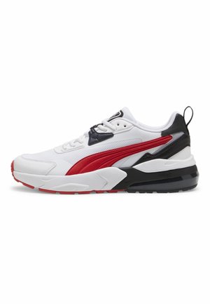 Weißer Sneaker mit roten und schwarzen Akzenten, dicker Sohle, Schnürung vorne und einer Schlaufe hinten.