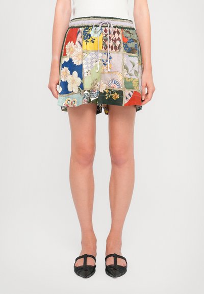 Kleurrijke patchwork rok met een elastische tailleband, trekkoord en decoratieve bloem- en geometrische patronen in verschillende levendige kleuren.