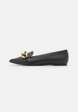 Schwarzer flacher Schuh mit spitzer Spitze, grauem Stoffoberteil und großer glänzender goldener Kettendekoration vorne.