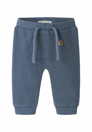 Pantalon tricoté bleu pour tout-petit avec chevilles revers, poche kangourou à l'avant et taille à cordon avec cordons blancs tachetés.