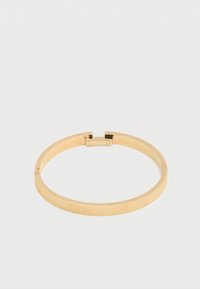 Βραχιόλι από μέταλλο σε χρυσό τόνο με ανάγλυφη υφή και μικρό κούμπωμα σε λευκό φόντο.