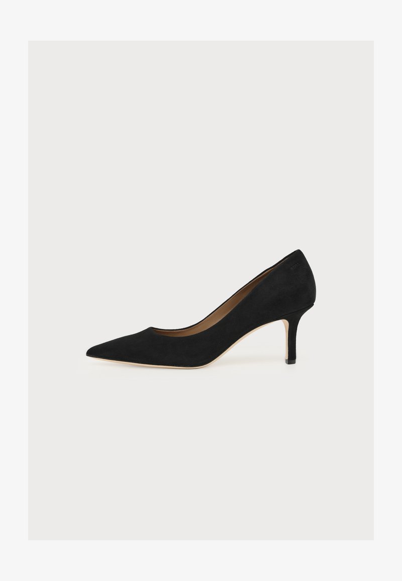 Escarpin en daim noir à bout pointu, talon aiguille de hauteur moyenne et semelle intérieure beige sur fond clair.