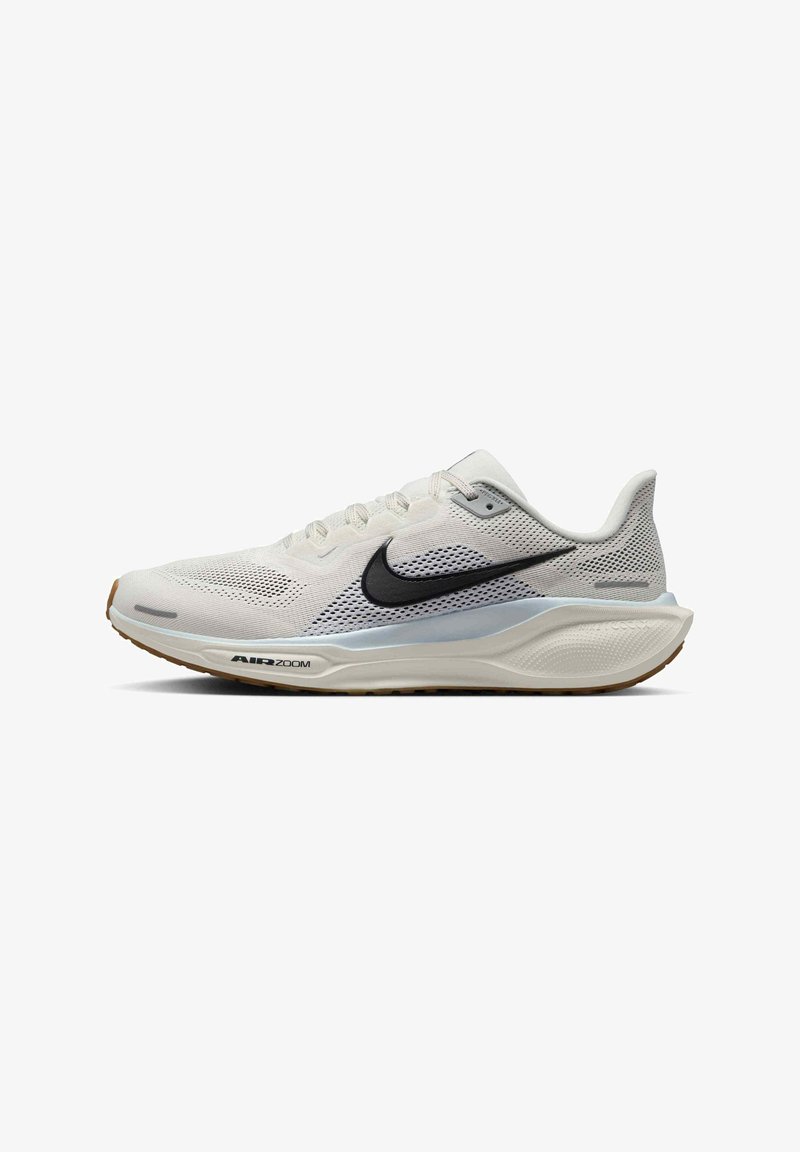 Chaussure de course Nike Air Zoom blanche avec un swoosh noir, tige en mesh et semelle amortissante avec légère semelle extérieure en gomme visible de côté.