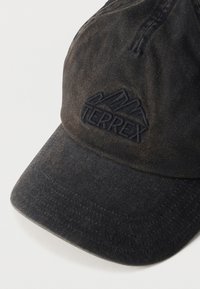 Μαύρο καπέλο μπέιζμπολ Terrex με κεντημένο λογότυπο βουνού στο μπροστινό μέρος, με ελαφρώς φθαρμένη υφή υφάσματος και κυρτό γείσο.