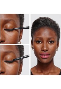 Zwarte eyelinerpotlood wordt aangebracht op het ooglid. Close-up van het gezicht van een model met een soepele huid, donker haar en een neutrale lipkleur.