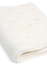 Coperta bianca e texturizzata con una superficie morbida e soffice. Presenta sottili strisce verticali in rilievo e un bordo arrotolato. Leggera e accogliente.