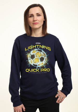 Sweat-shirt à manches longues bleu marine avec un graphisme de ballon de football, accents bleu électrique et jaune, portant le texte et le logo "Lightning Quick Pro".