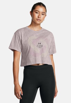 Izgriezts, gaišviolets T-krekls no mīksta auduma ar apaļu kakla izgriezumu. Priekšpusē ir grafisks teksts un krāsaini vājoļojoši raksti.