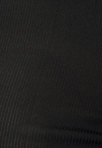 Černá ribstová tkanina s hladkým povrchem a vertikálními liniemi, která představuje monochromatický design bez výrazných akcentů nebo vzorů.