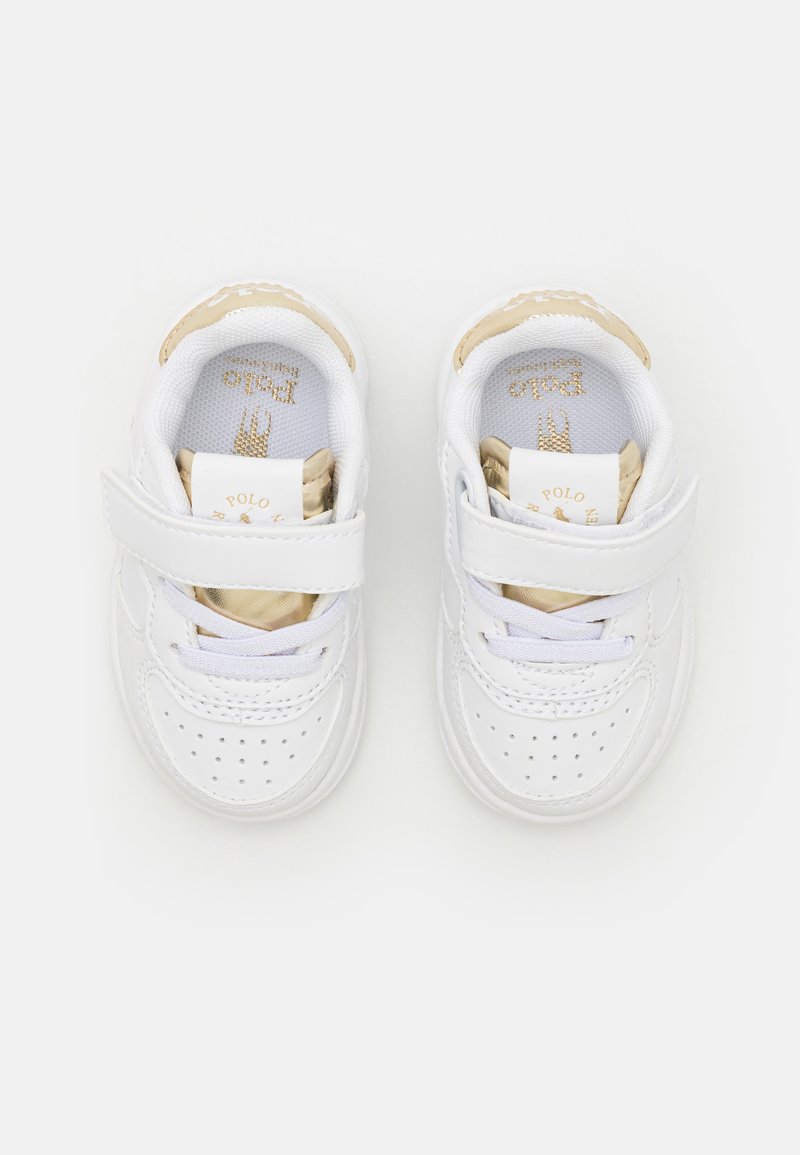 Baskets en cuir blanc pour tout-petits avec une sangle Velcro, des détails perforés et des accents dorés sur le talon et la doublure intérieure.