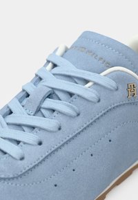 Ανδρικό αθλητικό παπούτσι από γαλάζιο σουέντ με λευκά κορδόνια, στρογγυλή μύτη, διακοσμητικές διατρήσεις και χρυσό λογότυπο στο πλάι. Λαστιχένια σόλα.