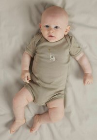 Beige kortermet body med en liten elefantgrafikk som holder en ballong, laget av mykt stoff, med trykknapper nederst.