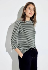 Gestreept top in groen en wit, met een ronde hals en driekwartmouwen. Draag het met zwarte broek, met een ontspannen pasvorm en trekkoord.