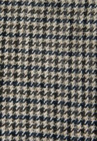 Villane segu kant, mis esitleb houndstooth mustrit mustas, beežis ja hallis värvitoonis, pehme tekstuuri ja erineva lõngapaksusega pinnaga.