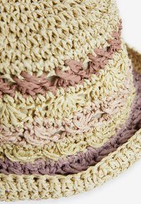 Chapeau en paille tissé avec un design texturé, présentant un dégradé de crème, rose clair et lavande, rehaussé de fils métalliques.