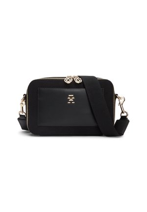 Sac bandoulière rectangulaire noir avec fermetures éclair dorées, poche avant, emblème doré et large sangle noire réglable.