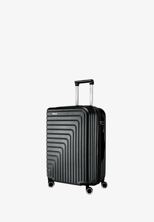 Valigia nera rigida con design scanalato, manico retrattile e quattro ruote per la mobilità. Presenta una chiusura con zip e un dettaglio del logo.