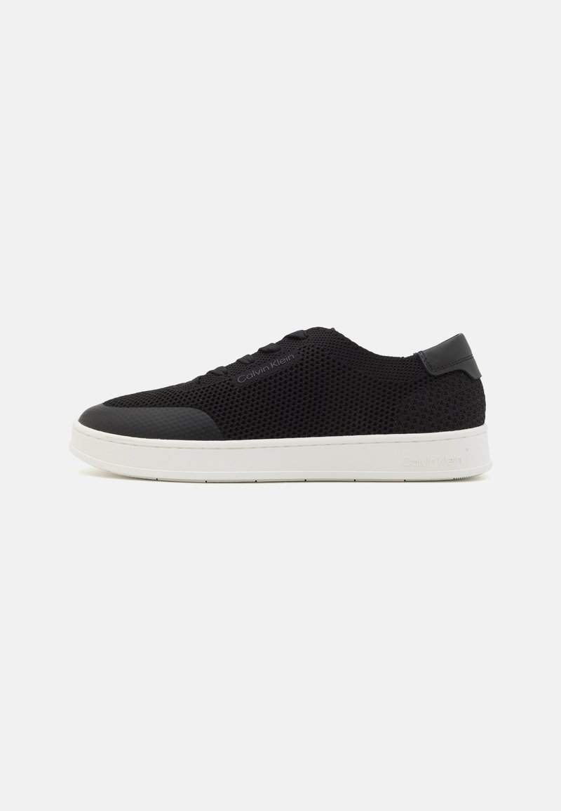 Baskets décontractées en mesh noir avec laçage à l'avant, semelle blanche et marque Calvin Klein sur le côté et la semelle, présentées de profil gauche.
