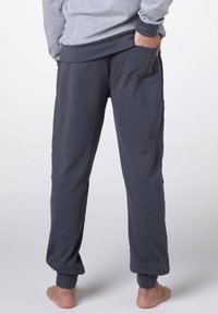 Pantaloni della tuta grigio carbone realizzati in morbida miscela di cotone, con vestibilità comoda, vita elasticizzata e orli con polsini. Tasche su entrambi i lati.