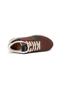 Brown sneaker with green accents, featuring a mix of suede and fabric materials, rounded toe, flat laces, and a textured rubber sole.