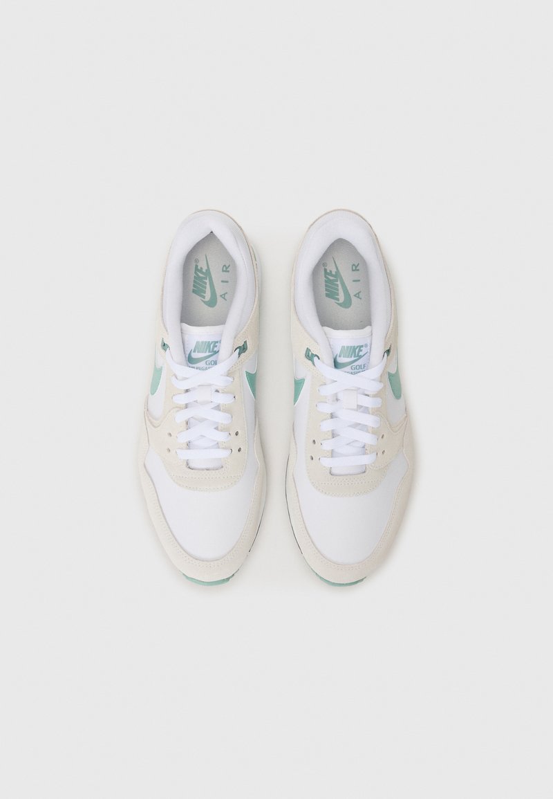 White and beige Nike Air sneakers with a mint green accent, featuring a smooth textile upper, lace closure, and visible cushioning sole.
