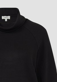Maglia nera a maniche lunghe con collo alto alla coreana, cucitura visibile sulle spalle e etichetta del marchio s.Oliver all'interno del collo su sfondo grigio chiaro.