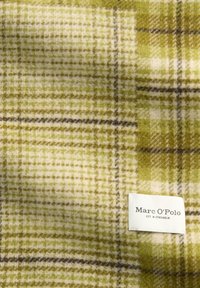 Zielono-kremowa tkanina w kratę z brązowymi akcentami. Miękka w dotyku, z drobnym wzorem kratki i białą metką z napisem "Marc O'Polo".