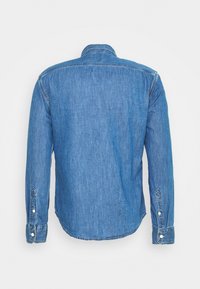 Jeansskjorta i en enfärgad blå nyans, med långa ärmar och klassisk krage. Den har knappärmar och en rundad nederkant.