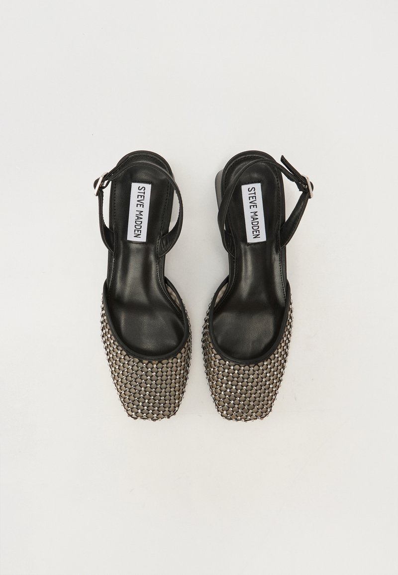 Tacchi slingback neri con punta quadrata, texture in rete metallica e soletta in pelle liscia. Cinghia regolabile per una vestibilità personalizzata.