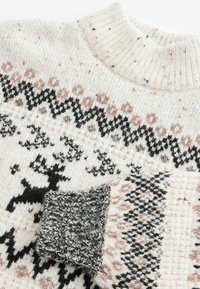 Stickad tröja i krämfärgad med svarta, rosa och grå geometriska mönster samt renar; har en hög ribbad krage och en texturerad svart manchet.