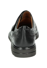 Zwarte instapschoen met een soepel leren bovenwerk, ronde hak, gewatteerde kraag en een lichtgevoerde rubberen buitenzool voor grip.