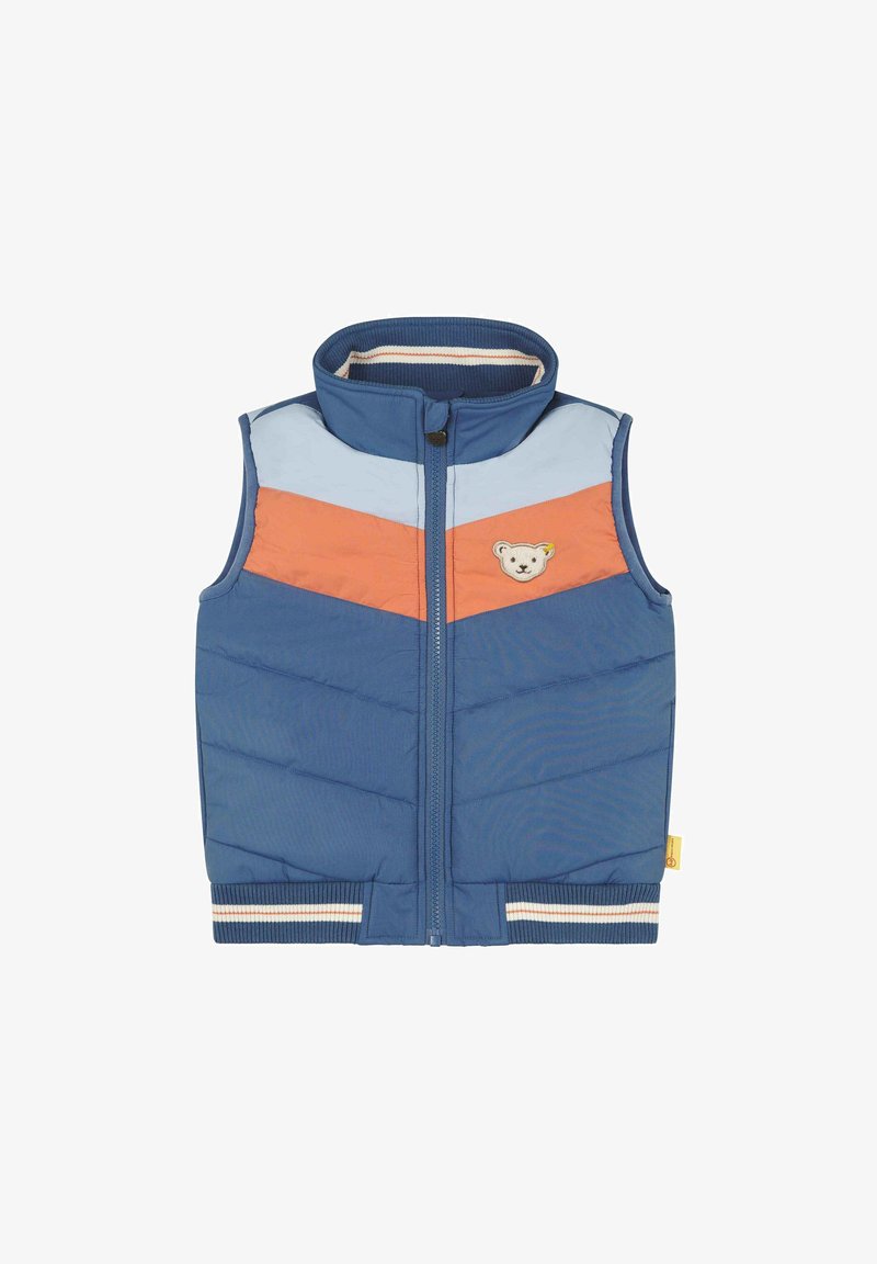 Veste sans manches matelassée bleue avec des rayures chevrons bleu clair et orange, fermeture éclair à l'avant, col et ourlet côtelés, et petit patch ours en peluche sur la poitrine.