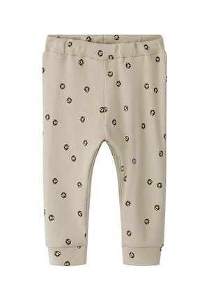 Beige ribbed pants featuring a dotted pattern with small brown and white flower designs, elastic waistband, and cuffed ankles.