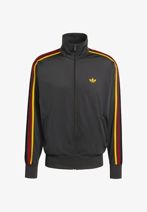 Černá zipová sportovní bunda s vysokým límcem, zdobená červenými, žlutými a černými pruhy na rukávech a malým žlutým logem na prsou.