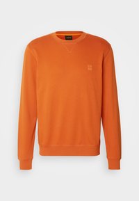 Sweat-shirt orange à manches longues et col rond avec poignets et ourlet côtelés, comportant un petit patch logo "BOSS" sur la poitrine gauche.