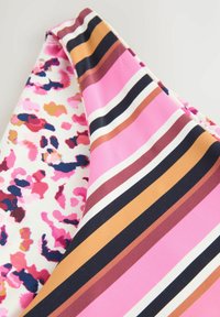 Twee stofstukken: het ene heeft een kleurrijke bloemenprint op wit, het andere heeft gedurfde horizontale strepen in roze, bruin en zwart.