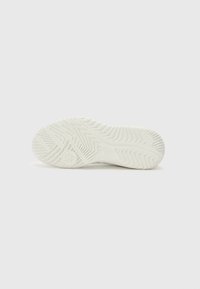 White rubber shoe sole with zigzag tread pattern, featuring a smooth texture and circular logo detail near the heel.