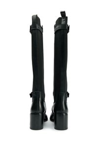 Black leather knee-high boots with a smooth finish, featuring a block heel, side zippers, and fabric panels for flexibility.