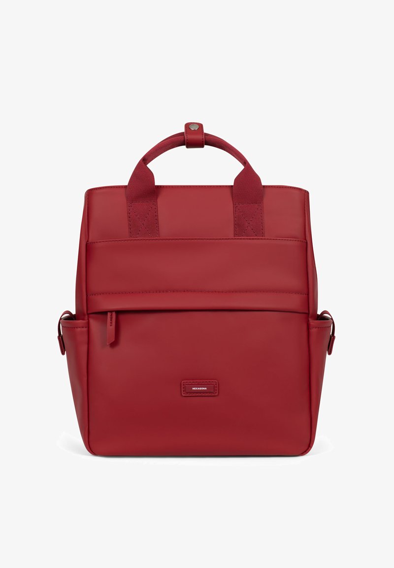 Sac à dos en cuir rouge avec deux poignées supérieures, poche avant et compartiment latéral. Texture lisse avec un minimum de détails métalliques.