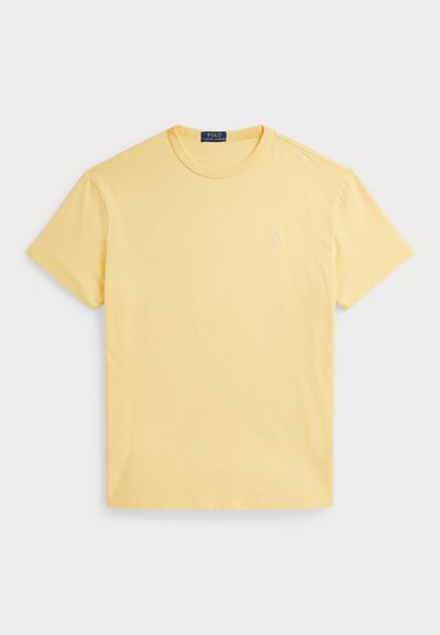 Gul kortermet t-skjorte laget av bomull, med rund hals og liten brodert logo på venstre bryst. Myk, glatt tekstur.