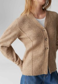 Cardigan beige in materiale morbido con scollo a V, cinque bottoni e polsini a coste. Presenta una vestibilità rilassata e dettagli con cuciture verticali.