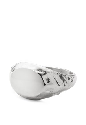 Hopeinen sinettisormus, jossa sileä ovaali pintakuvio ja vasaratyylinen kuvioitu sormi. Valkoisella taustalla.