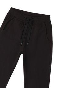 Schwarze Jogginghosen aus weichem Material, mit elastischem Bund und Kordelzug, seitlichen Taschen, glatter Oberfläche und ohne sichtbare Muster.