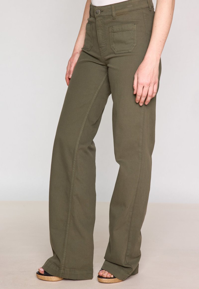 Pantalons larges vert olive en tissu mélangé de coton, dotés de poches avant, d'une taille haute et d'une texture lisse.