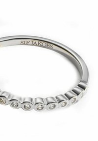 Silverring med vågig design som växlar mellan släta och fasetterade sektioner, prydd med små klara kristaller. Inskription "SIF JAKOBS."