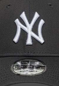 Μαύρο καπέλο με λευκό κεντημένο λογότυπο NY, με κυρτή γείσο και ρυθμιζόμενο λουρί. Σήμανση New Era στην ετικέτα σε κυκλικό σχέδιο.