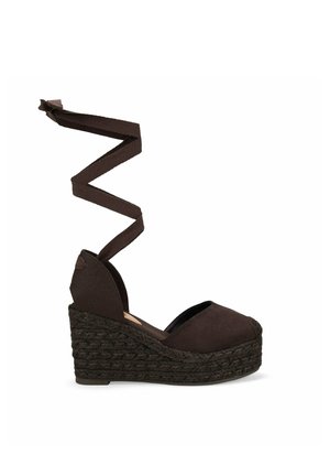 Alpargata marrón con cuña, puntera cerrada y lazo para anudar al tobillo, con suela plataforma trenzada de yute.